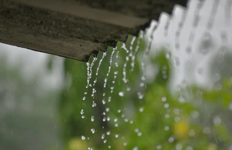 Rainwater pouring off a roof edge